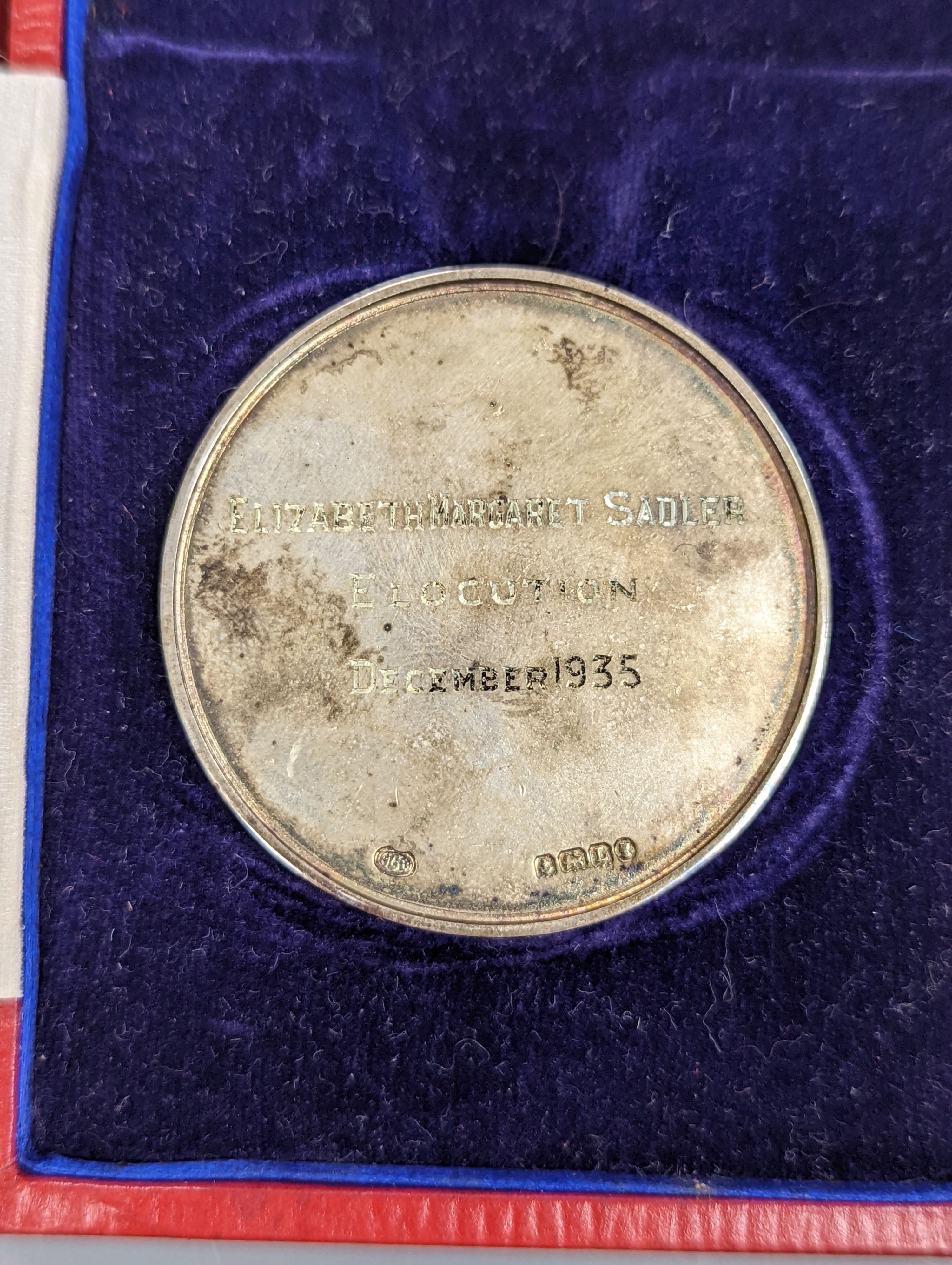 A silver Guildhall School elocution medal, 1935, and a humorous watercolour